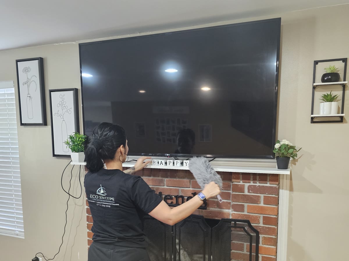 An Eco Sweeps cleaner dusting a fireplace mantel in a family home